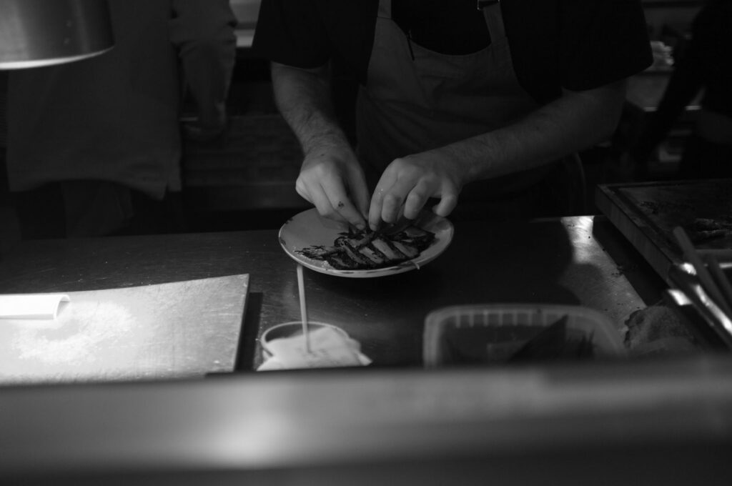 food styling restaurante — chef posicionando elementos do prato para a câmera